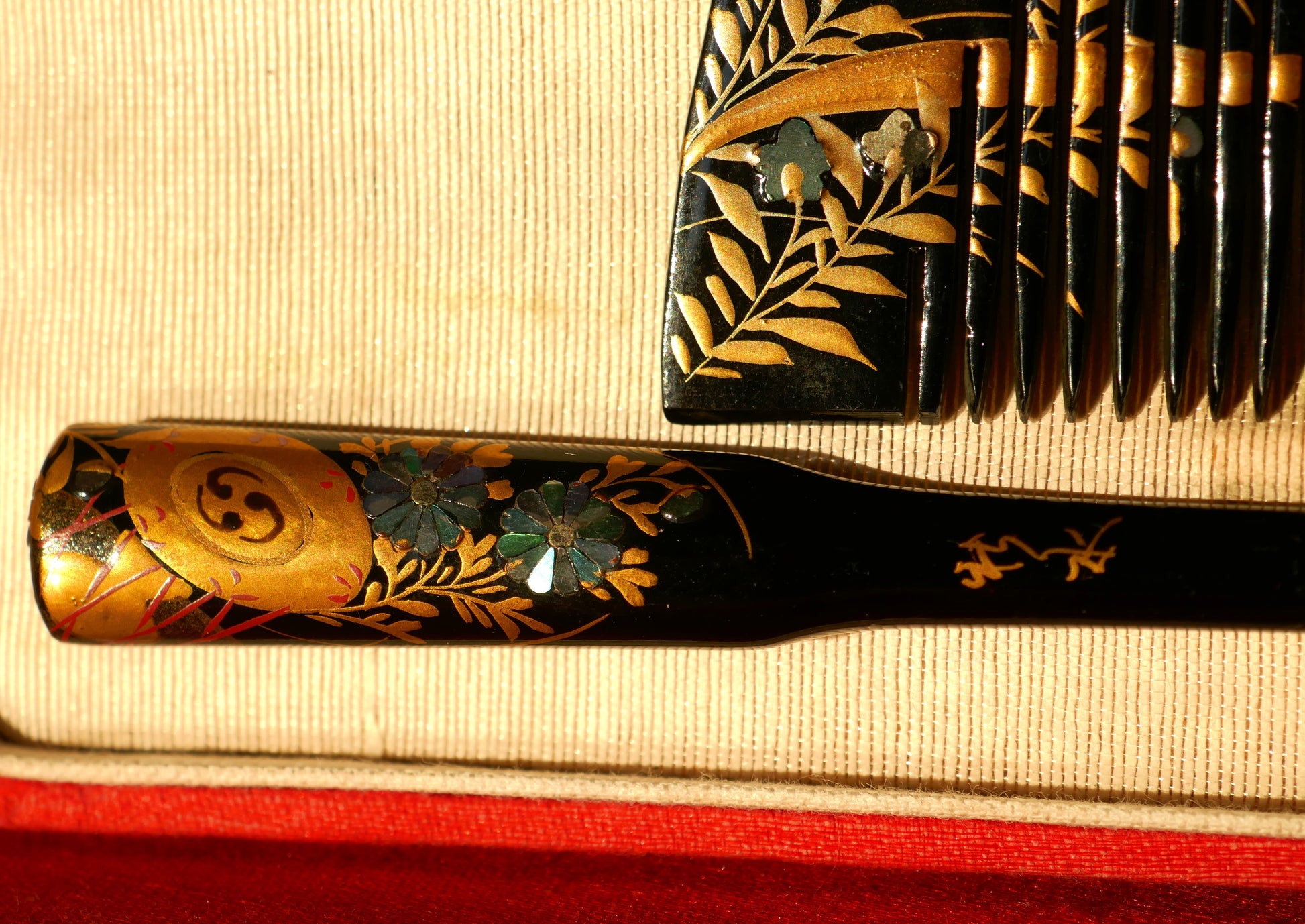 Détail du manche du kogai kogedo montrant les incrustations en nacre et la dorure en maki-e sur un décor végétal raffiné.
