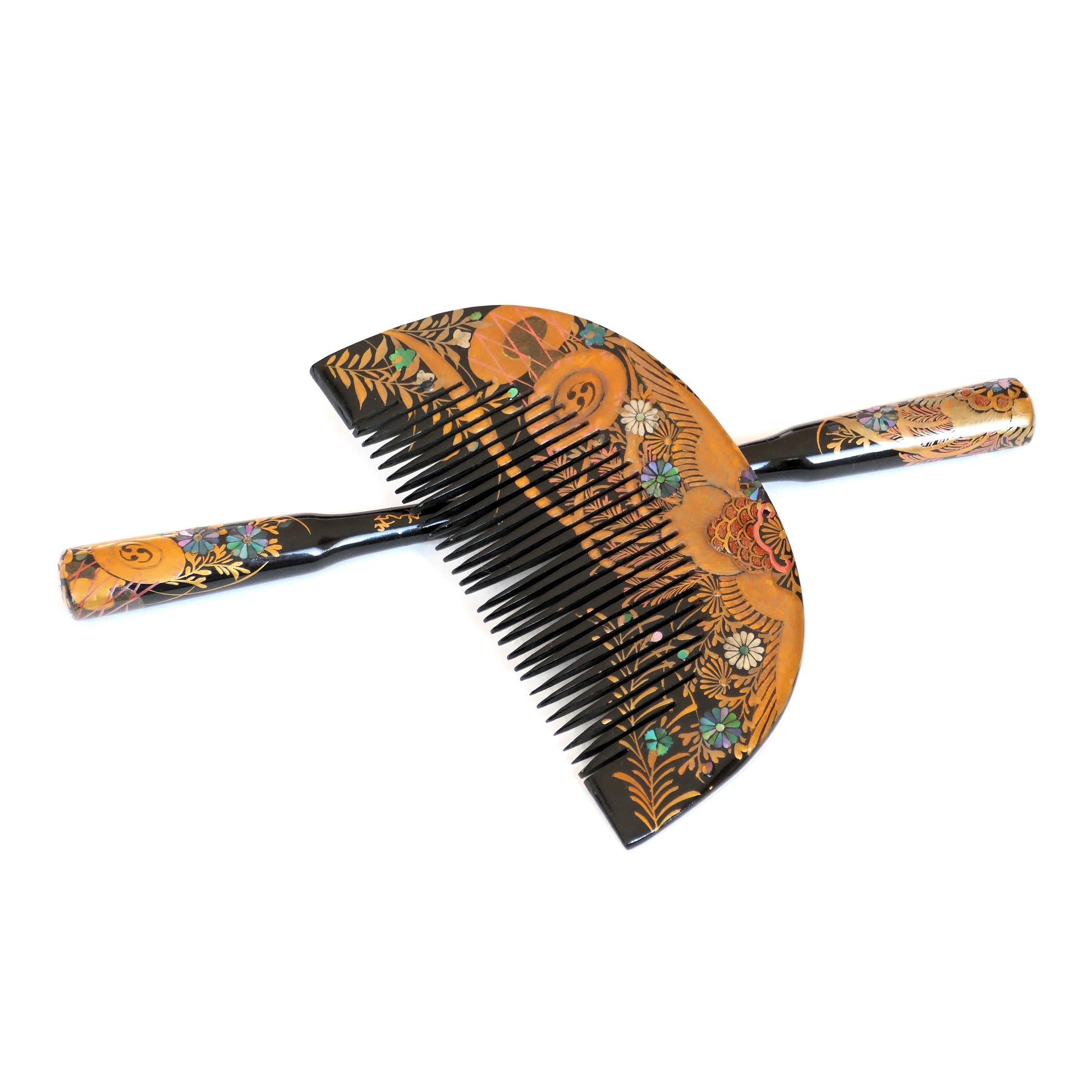 Ensemble Kushi & Kogai japonais ancien, croisé sur fond blanc, orné de motifs floraux, de nacre et de dorure.