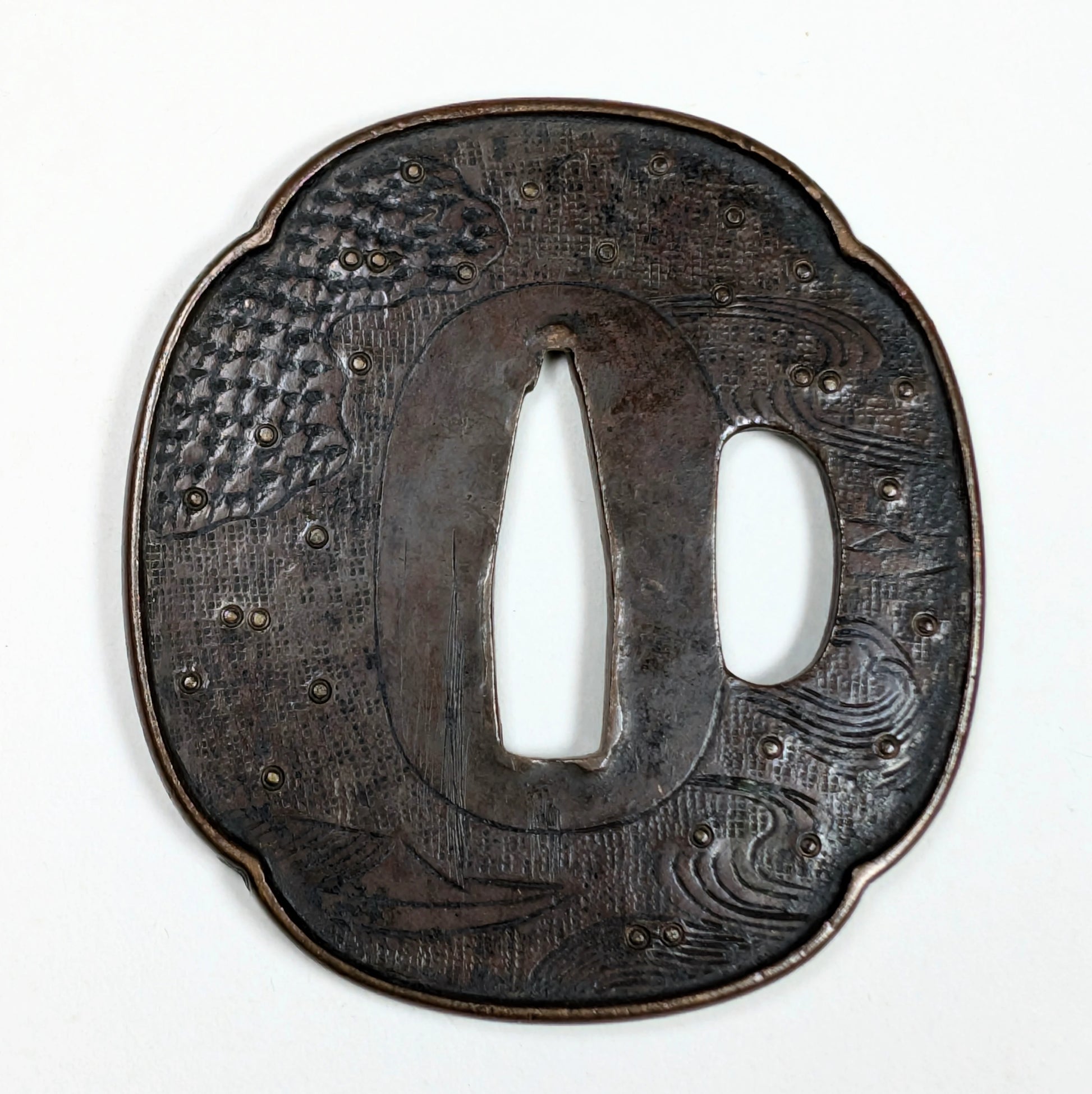 Tsuba de wakizashi en fer, école Shoami, époque Edo tardif, décor gravé de vagues et petits bateaux stylisés.