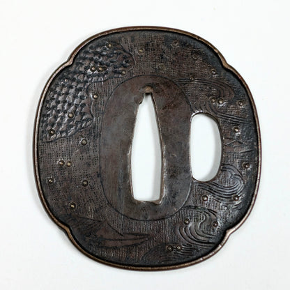 Tsuba de wakizashi en fer, école Shoami, époque Edo tardif, décor gravé de vagues et petits bateaux stylisés.