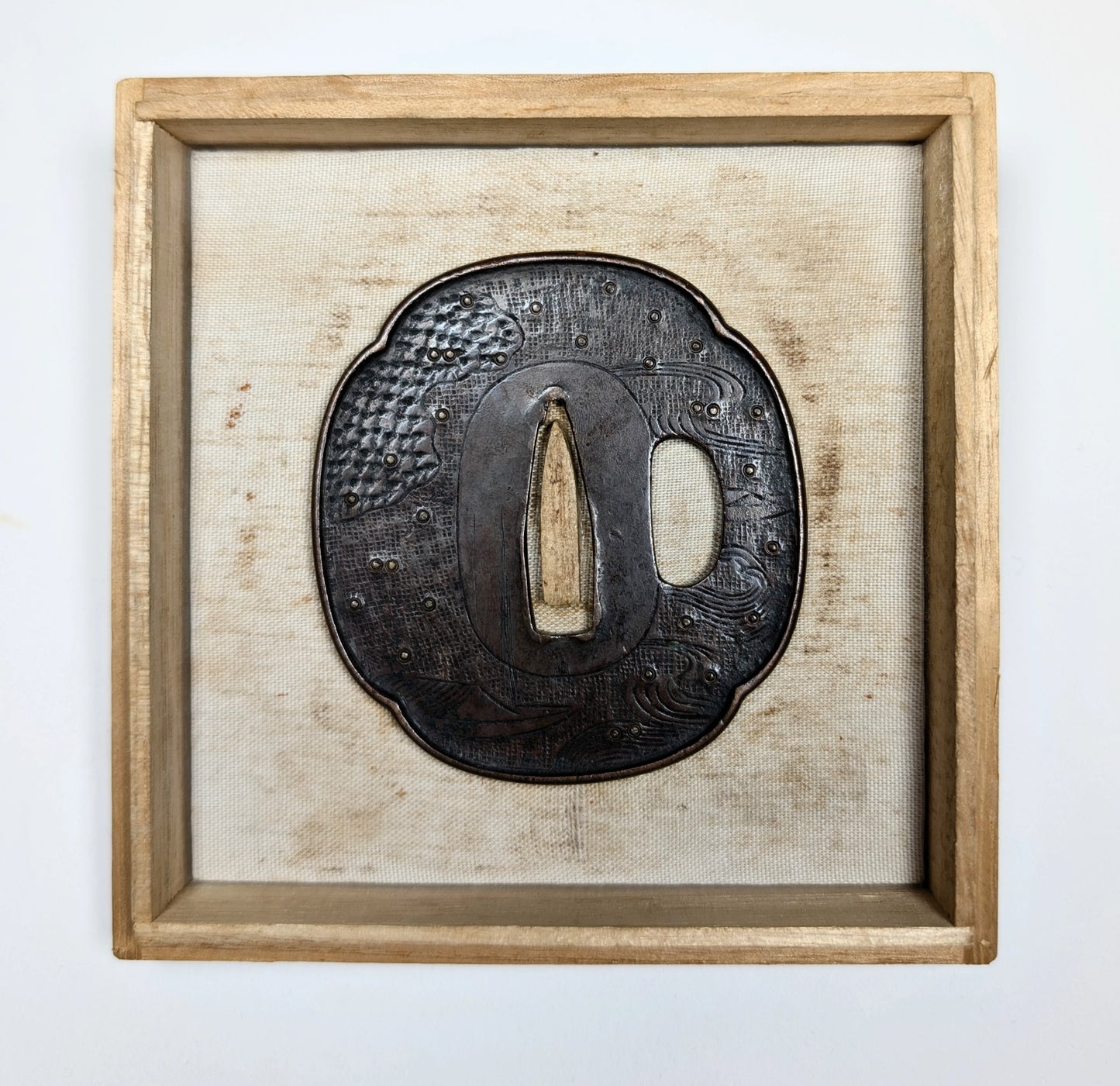 Tsuba japonaise ancienne Shoami exposée dans un cadre, fer Edo tardif avec décor de vagues et bateau, pièce de koshirae.