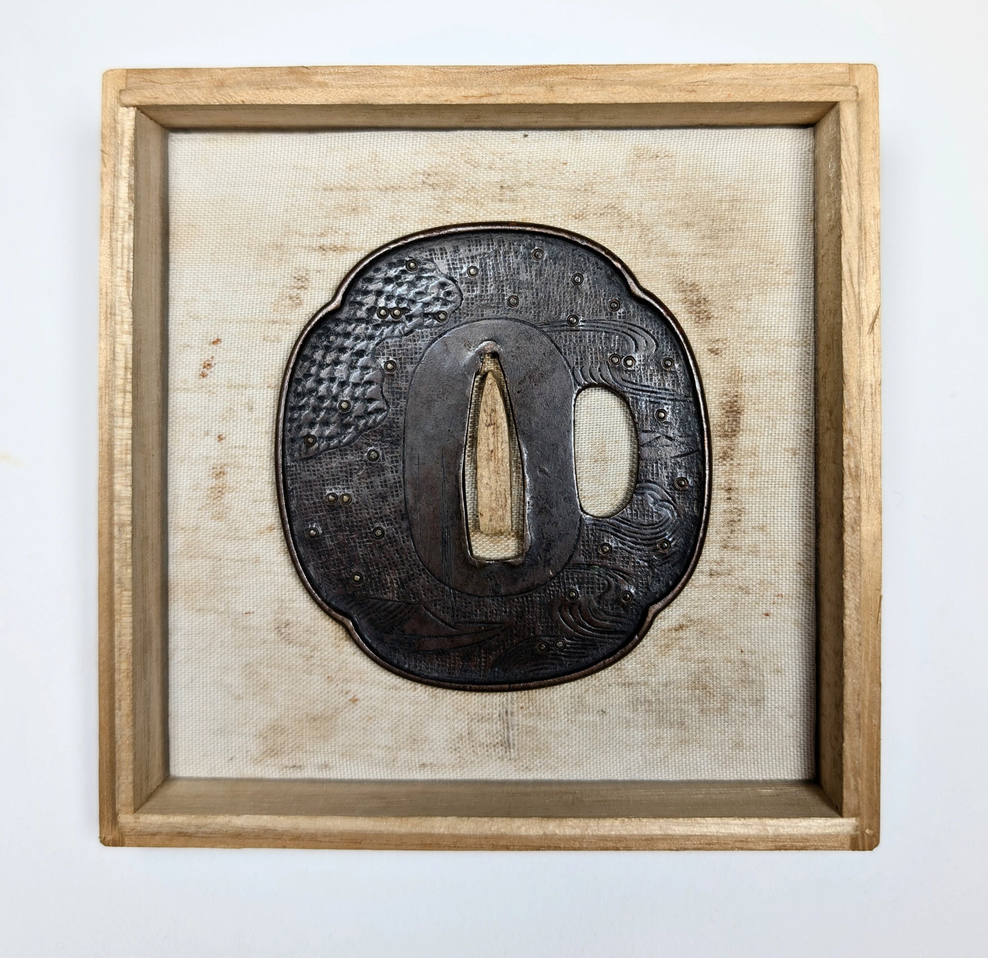 Tsuba japonaise ancienne Shoami exposée dans un cadre, fer Edo tardif avec décor de vagues et bateau, pièce de koshirae.