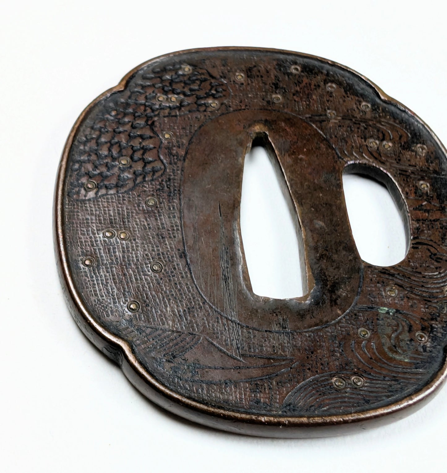 Détail de tsuba japonaise Edo tardif, gravure fine représentant des vagues et un bateau, travail Shoami en fer.