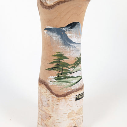 Gros plan sur le décor de paysage japonais et l’étiquette Arima Onsen d’une kokeshi omiyage authentique