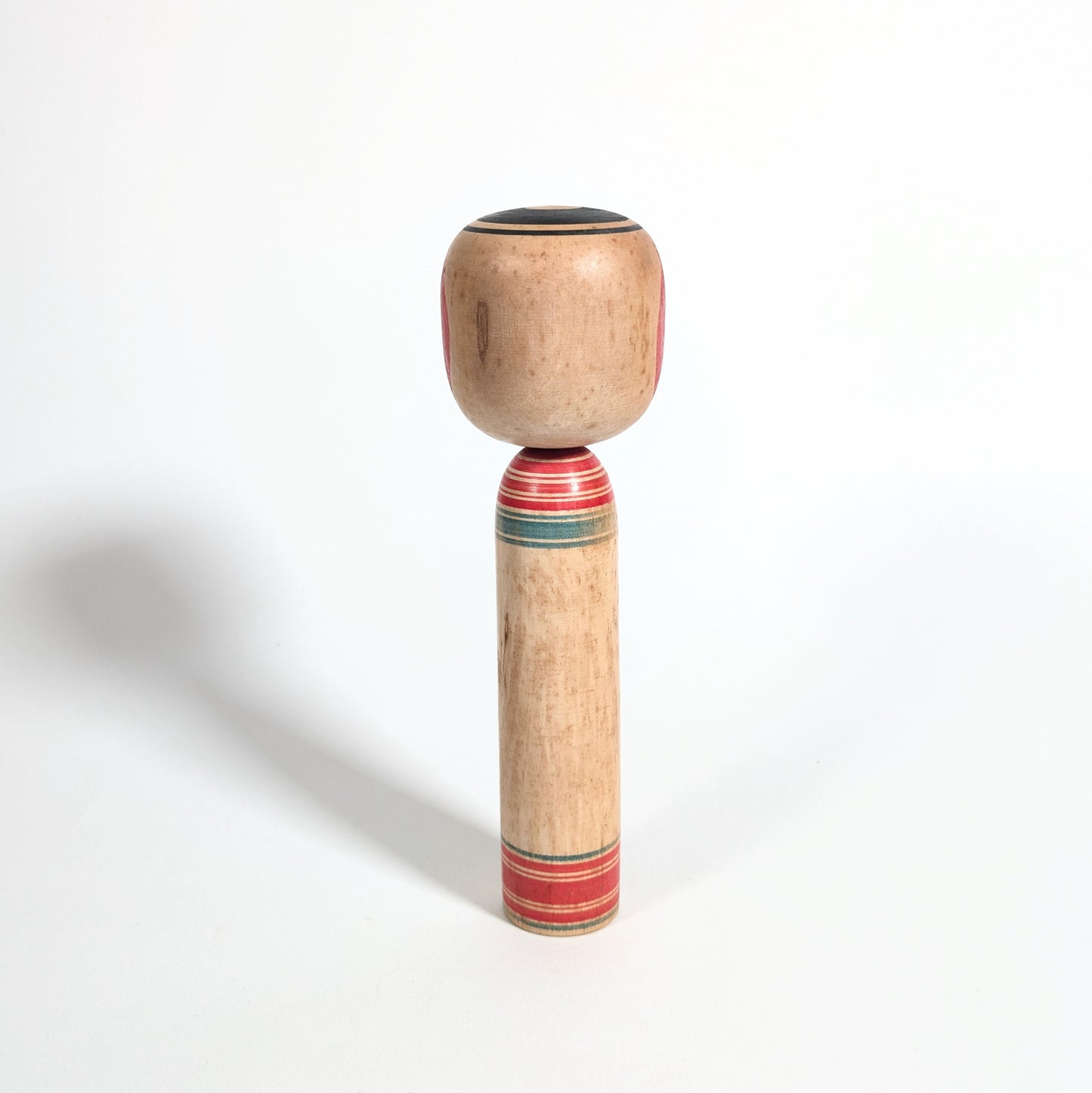 Arrière d’une kokeshi artisanale japonaise en bois tourné, style Tsuchiyu, objet d’art populaire du Japon époque Showa.