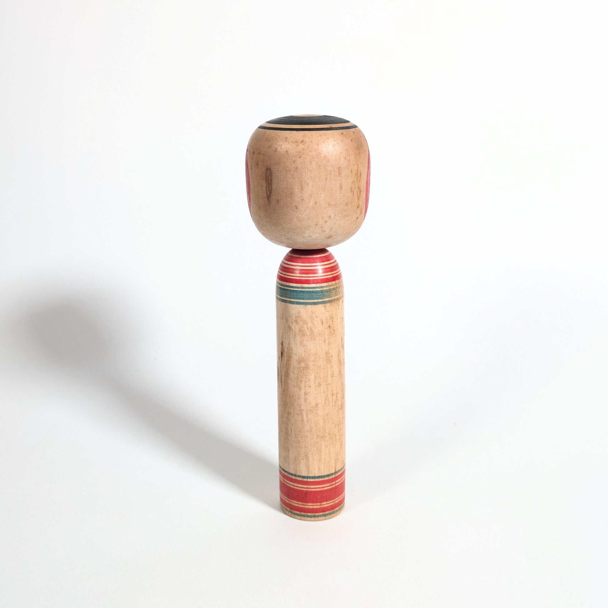 Arrière d’une kokeshi artisanale japonaise en bois tourné, style Tsuchiyu, objet d’art populaire du Japon époque Showa.