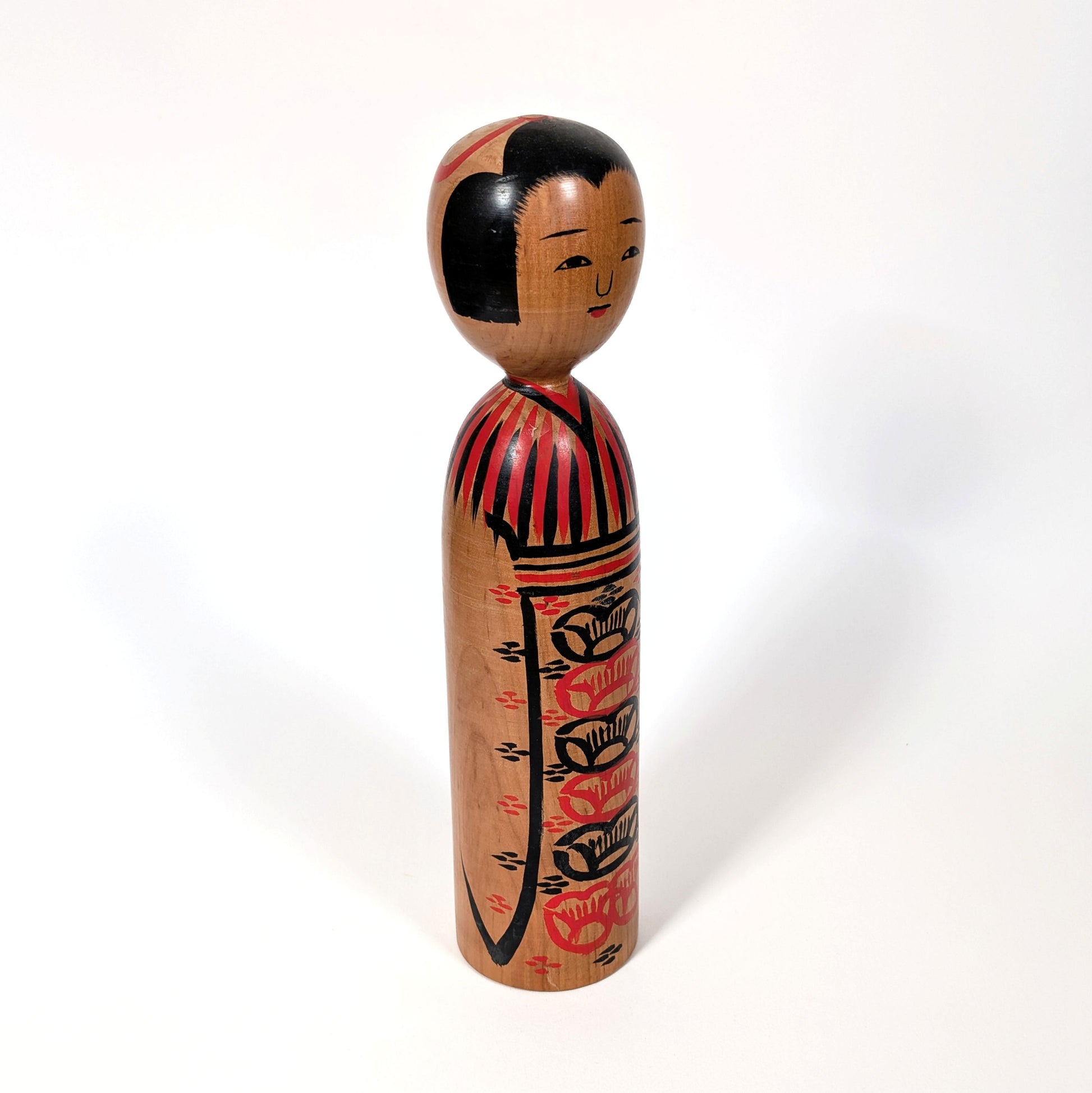 Kokeshi japonaise ancienne en bois, détail de la peinture traditionnelle rouge et noire