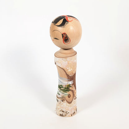 Kokeshi en bois avec écorce naturelle, souvenir d’onsen japonais décoré d’un paysage peint sur le corps