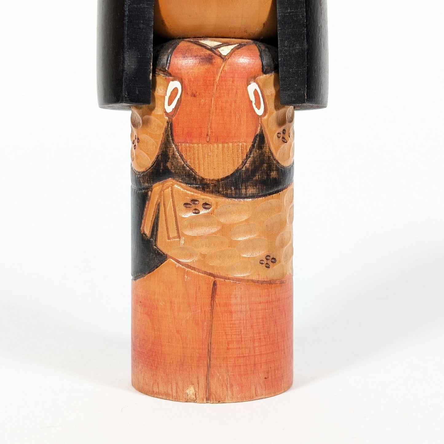 Détail du kimono gravé sur une kokeshi en bois sculpté, artisanat japonais traditionnel