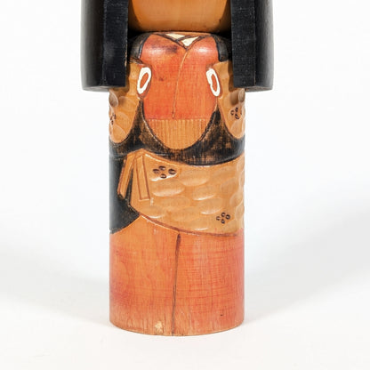 Détail du kimono gravé sur une kokeshi en bois sculpté, artisanat japonais traditionnel