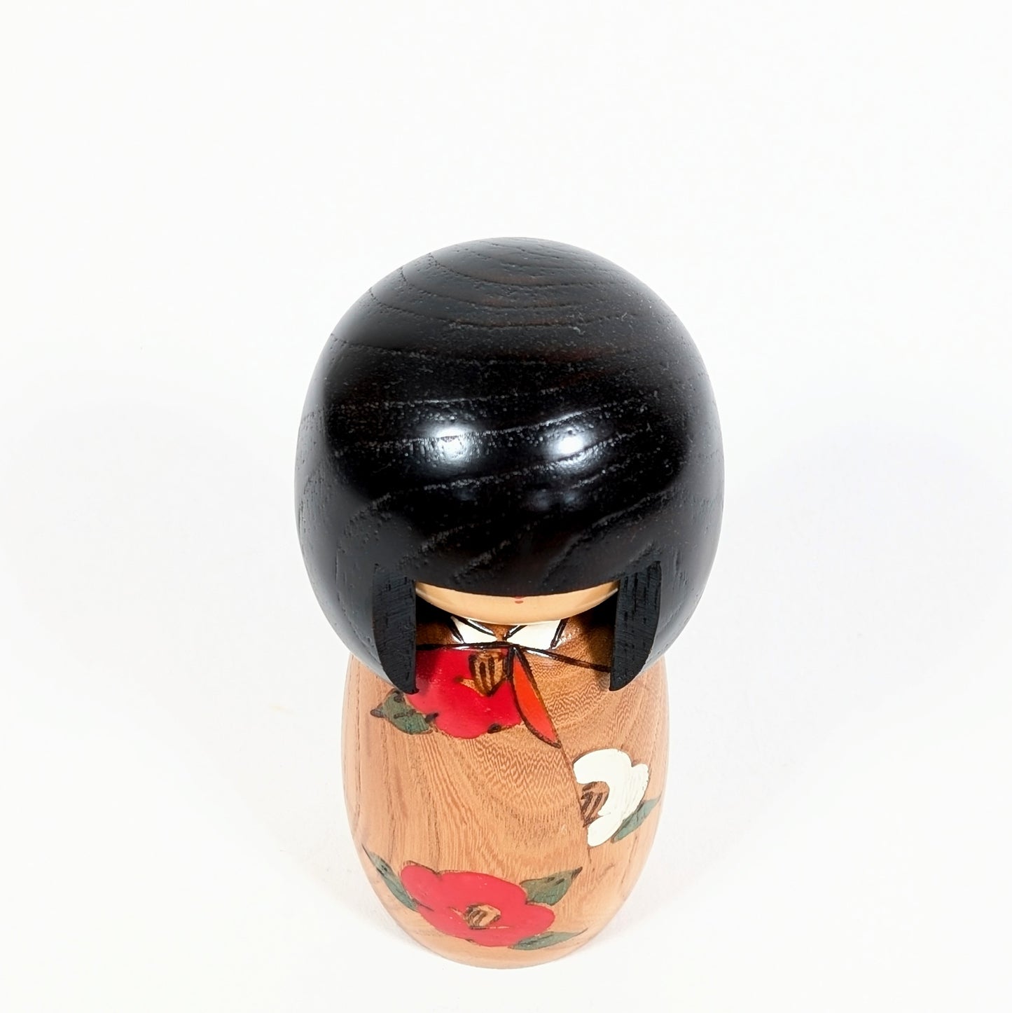 Vue du dessus d’une kokeshi créative japonaise Usaburo Haru no uta, poupée en bois à tête ronde laquée noire