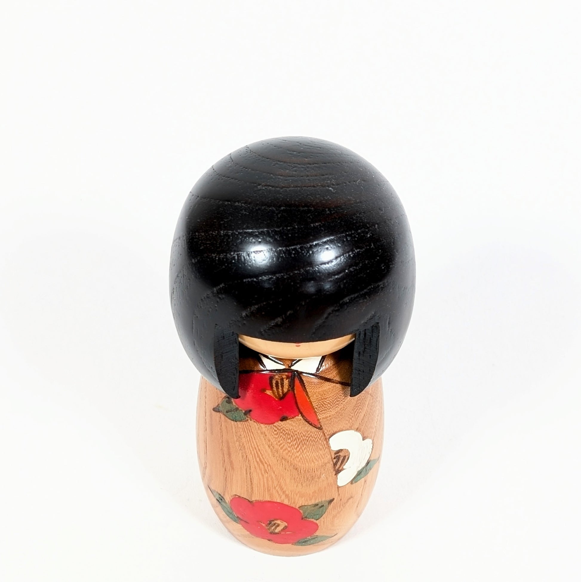 Vue du dessus d’une kokeshi créative japonaise Usaburo Haru no uta, poupée en bois à tête ronde laquée noire