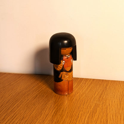 Kokeshi japonaise vintage en situation, objet décoratif en bois dans un intérieur chaleureux