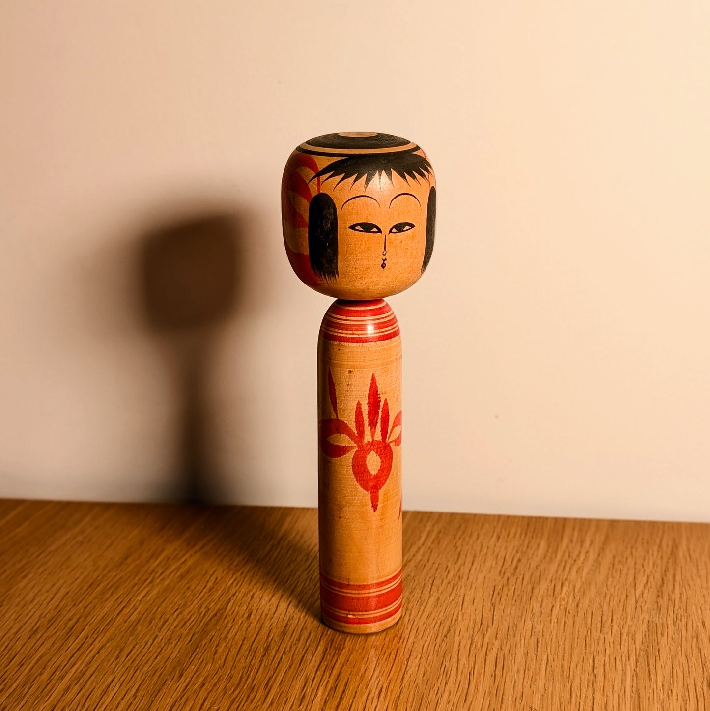 Kokeshi décorative japonaise en bois avec motif floral rouge, artisanat traditionnel du Japon style Tsuchiyu.
