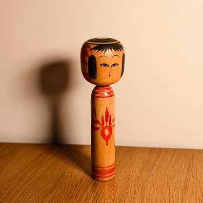 Kokeshi décorative japonaise en bois avec motif floral rouge, artisanat traditionnel du Japon style Tsuchiyu.