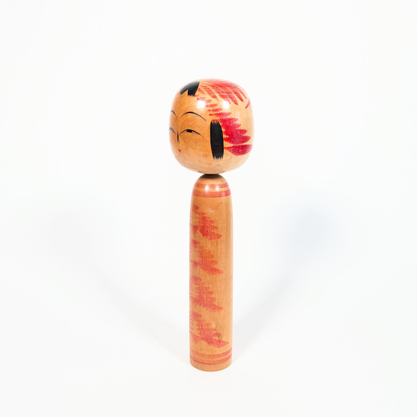 Kokeshi vintage style Togatta, profil trois quarts avec décor tegara sur la tête et motif kasanegiku rouge sur bois naturel.