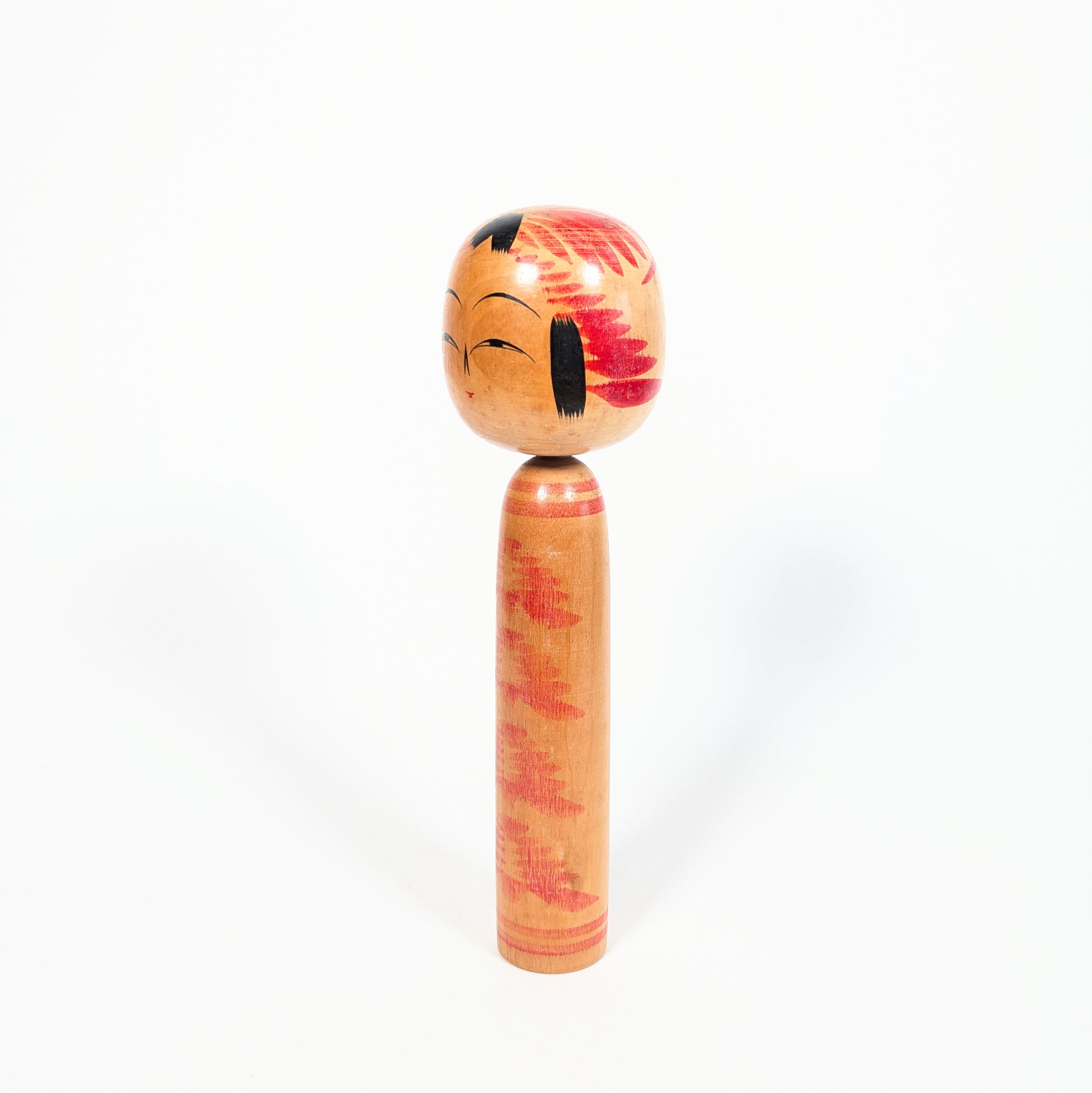Kokeshi vintage style Togatta, profil trois quarts avec décor tegara sur la tête et motif kasanegiku rouge sur bois naturel.