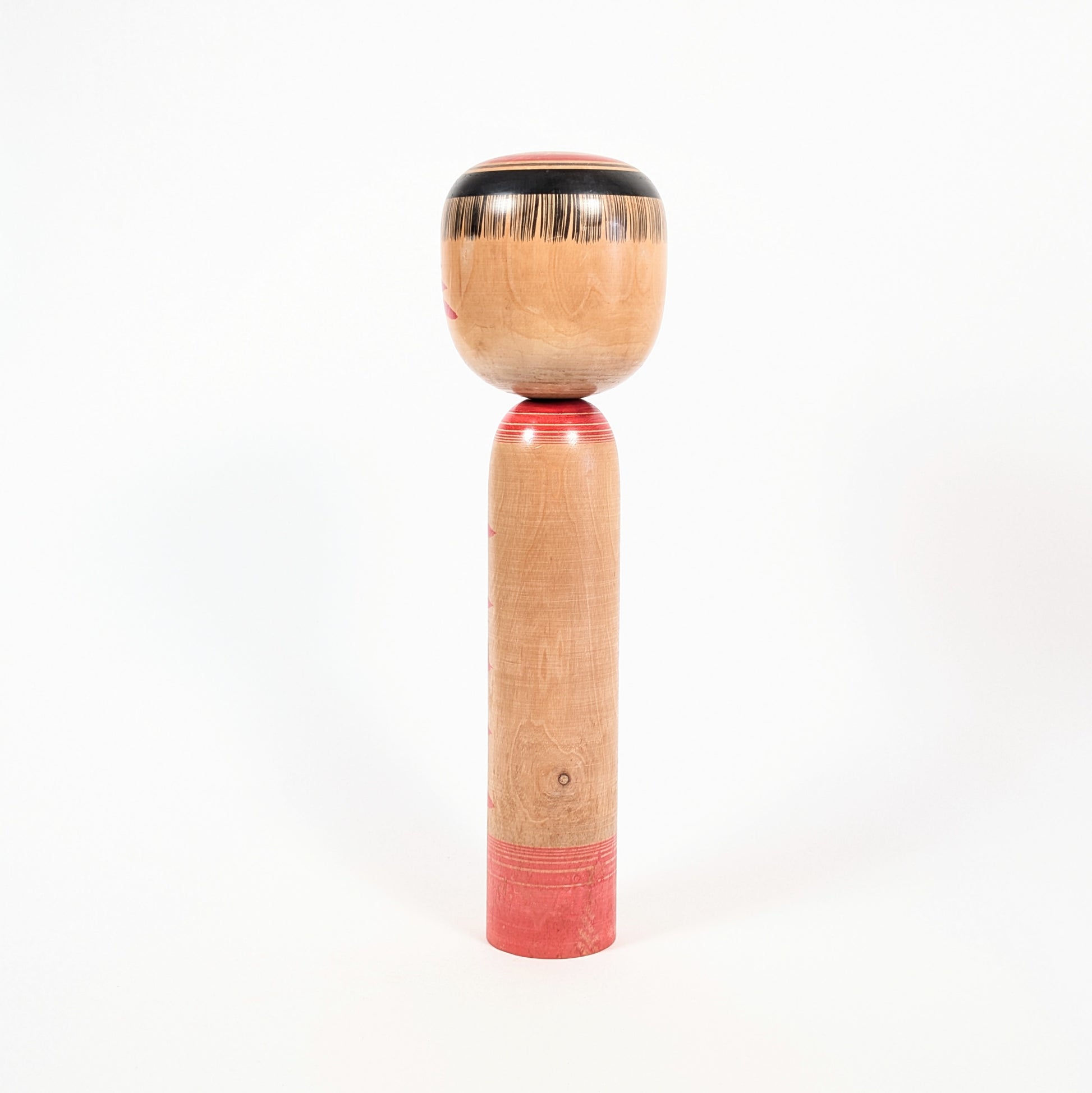 Dos de la kokeshi dentō Yajirō de Kamata Kōichi, révélant le bois tourné, son veinage naturel et sa patine.
