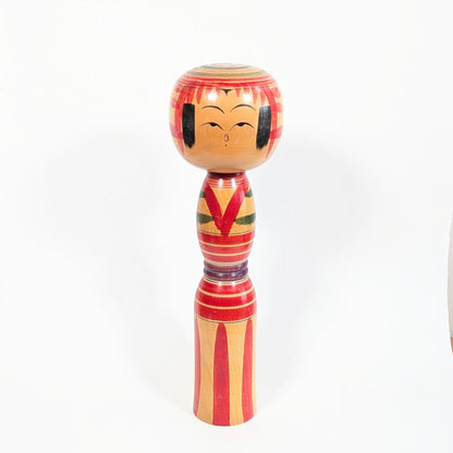 Kokeshi dentō Yajirō-kei de grande taille, poupée japonaise en bois tourné avec tête ronde, kimono stylisé rouge et visage souriant
