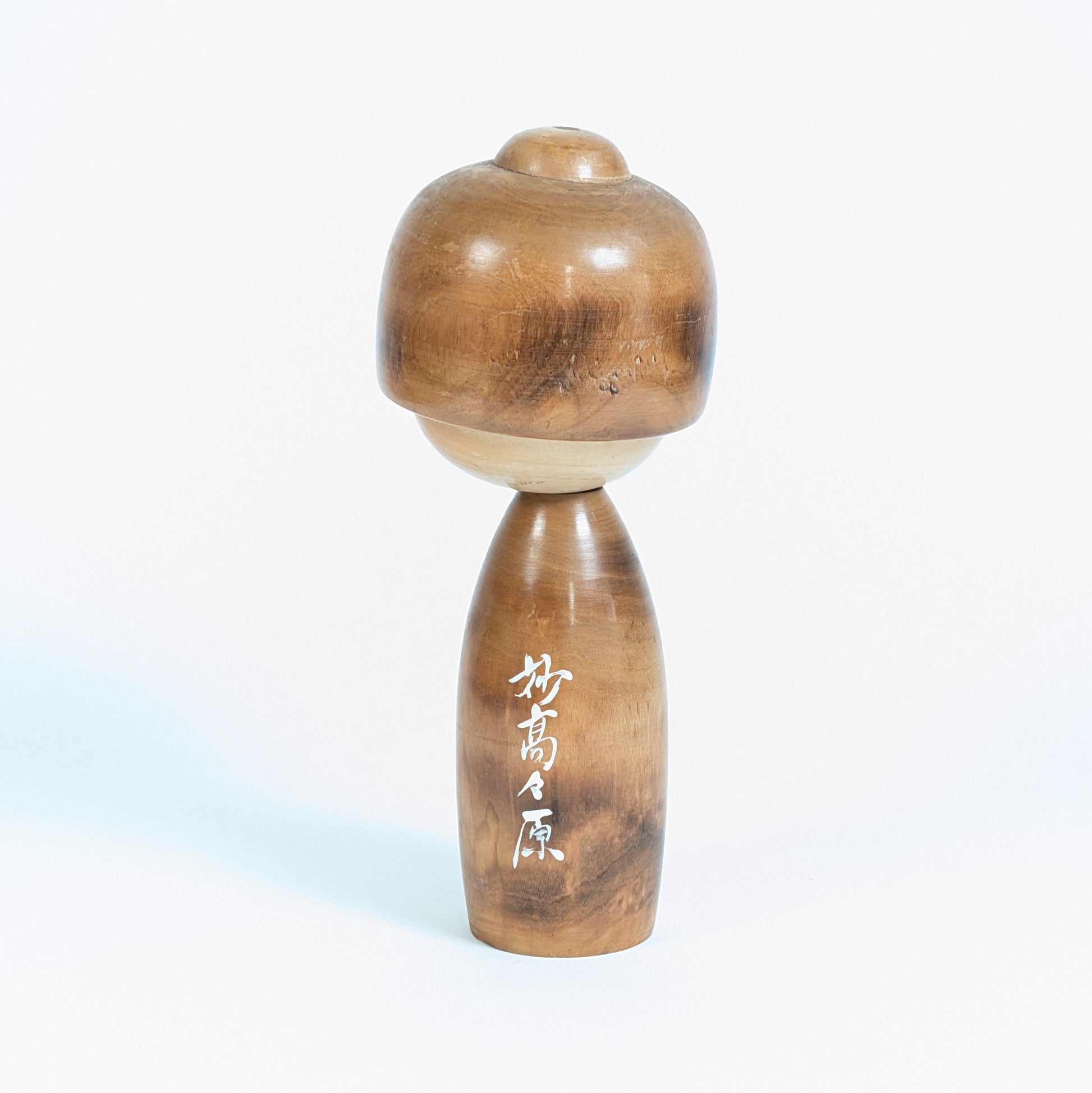 Dos de la kokeshi Fujikawa Masae avec inscription japonaise Myōkō Kōgen 妙高々原 peinte en blanc