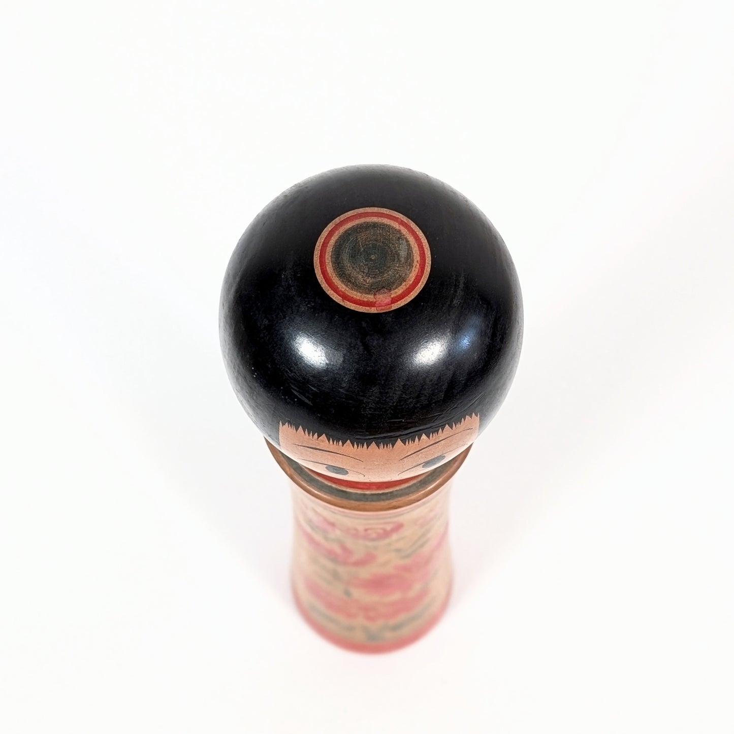 Vue du janome sur la tête d’une kokeshi Ginzan Oshin, coiffure okappa noire et finition artisanale japonaise