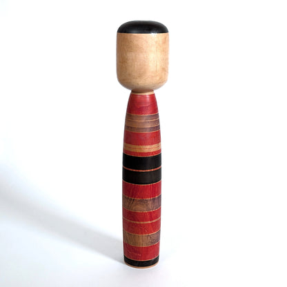 Dos d’une kokeshi poupée japonaise ancienne en bois naturel, finition artisanale traditionnelle japonaise