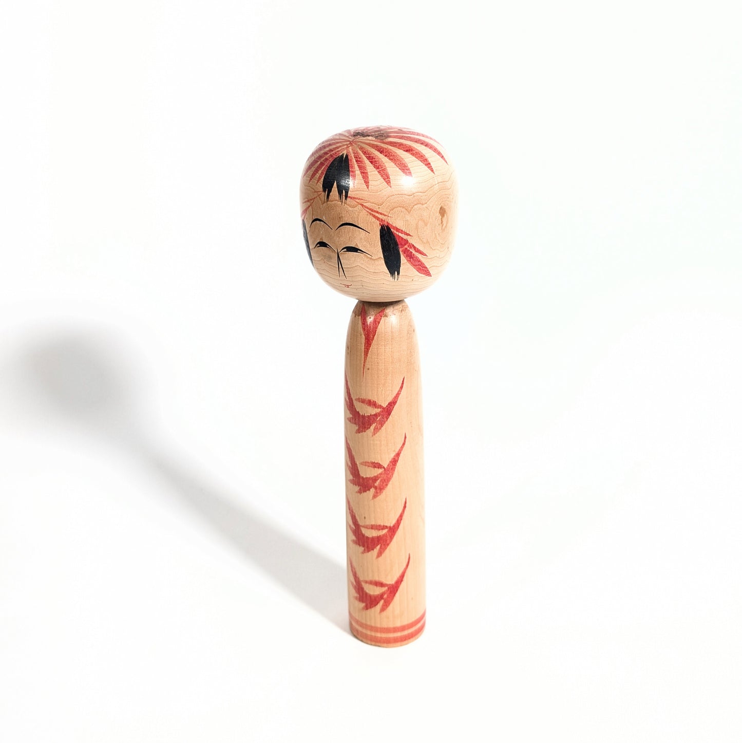 Vue de profil d’une kokeshi japonaise ancienne Togatta-kei, artisanat traditionnel japonais