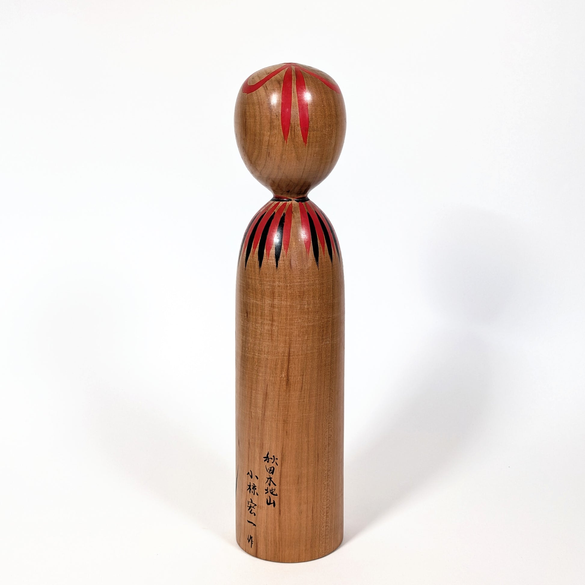 Dos d’une kokeshi japonaise traditionnelle en bois de yamazakura, finition naturelle artisanale