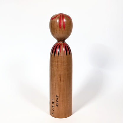 Dos d’une kokeshi japonaise traditionnelle en bois de yamazakura, finition naturelle artisanale