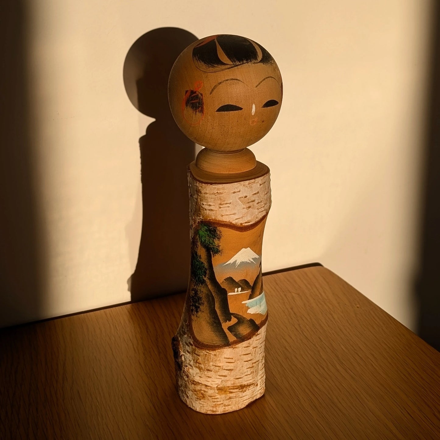 Kokeshi japonaise omiyage éclairée par le soleil, décor Mont Fuji et lac – décoration japonaise traditionnelle.