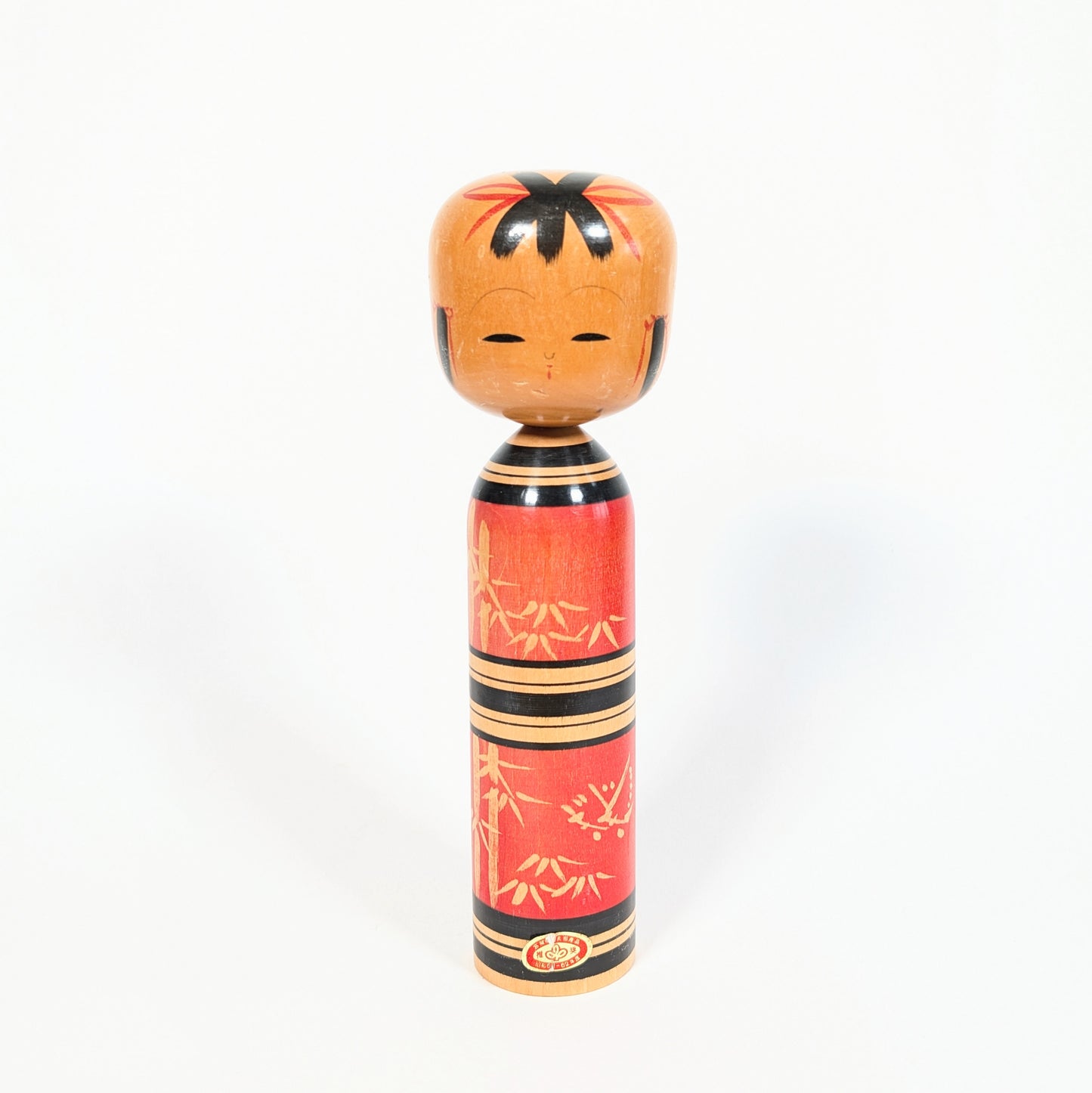 Kokeshi japonaise vintage sosaku de Kawamura Shōji, modèle Showa 61-62 avec décor bambou rouge et noir