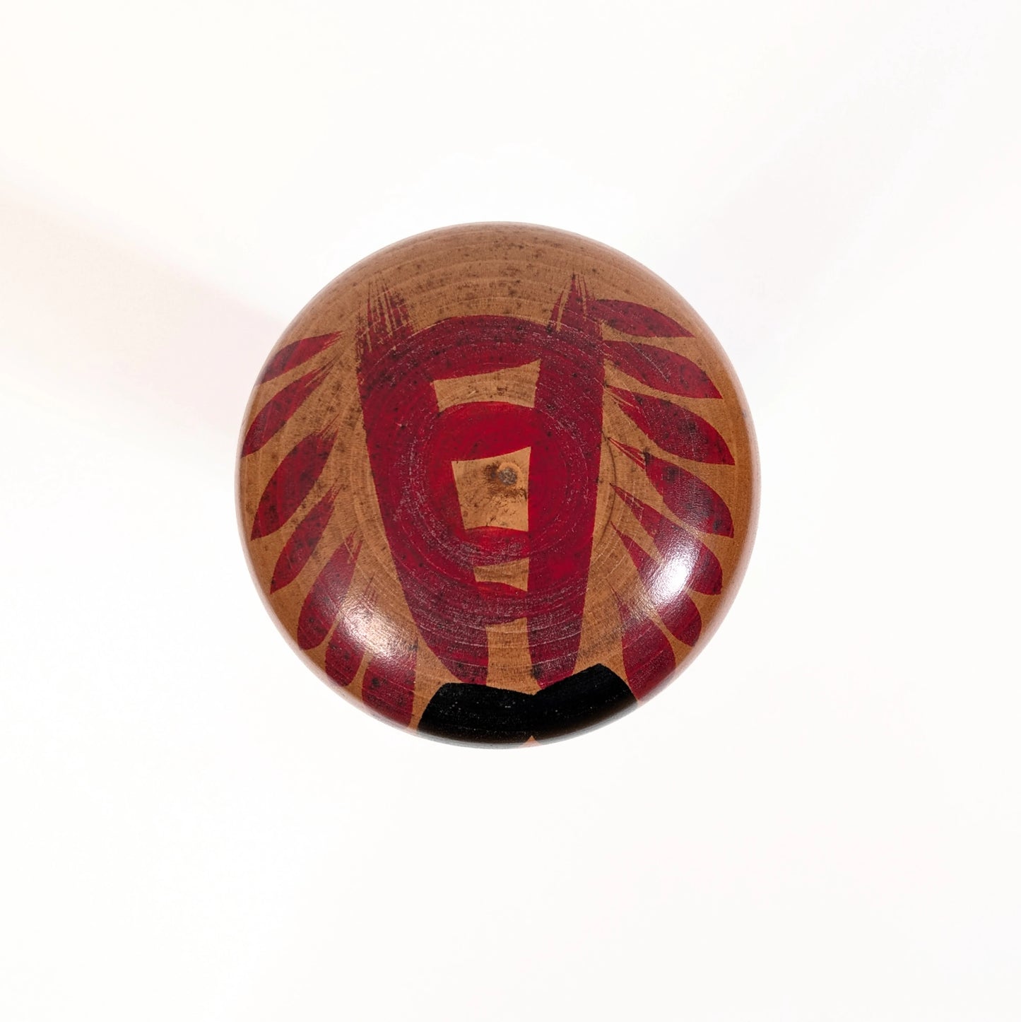 Vue du sommet d’une kokeshi Togatta japonaise, motifs tegara peints traditionnels sur la tête