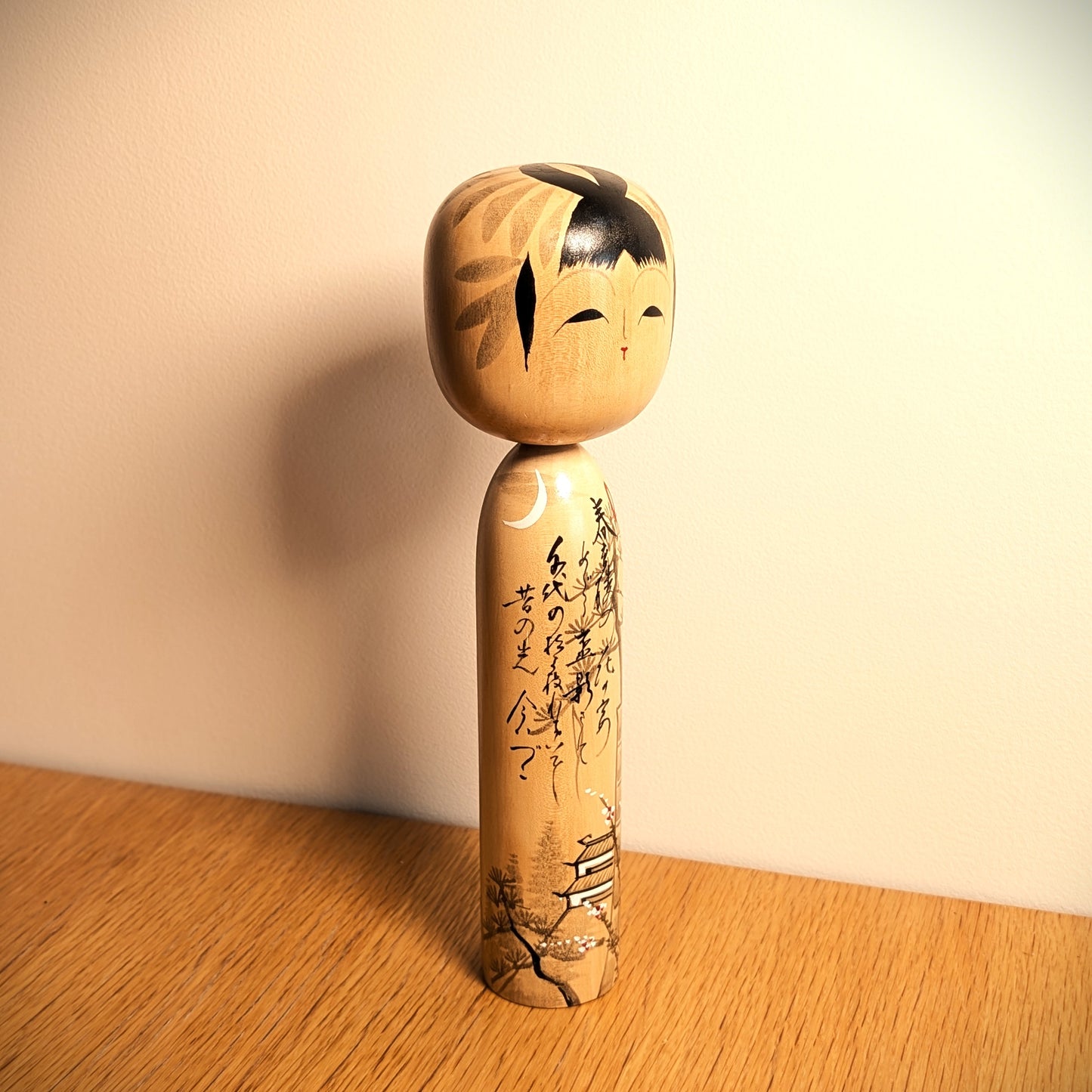 Kokeshi japonaise vintage Shūhō, modèle Kōjō no Tsuki, présentée en décoration sur un meuble en bois.