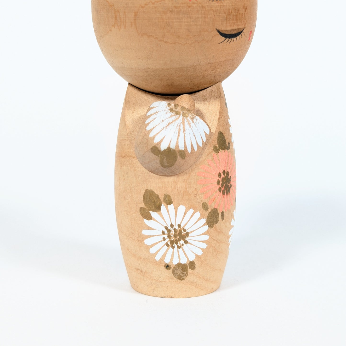 kokeshi japonaise visage yeux fermes fleurs blanches style sosaku artisanat japonais