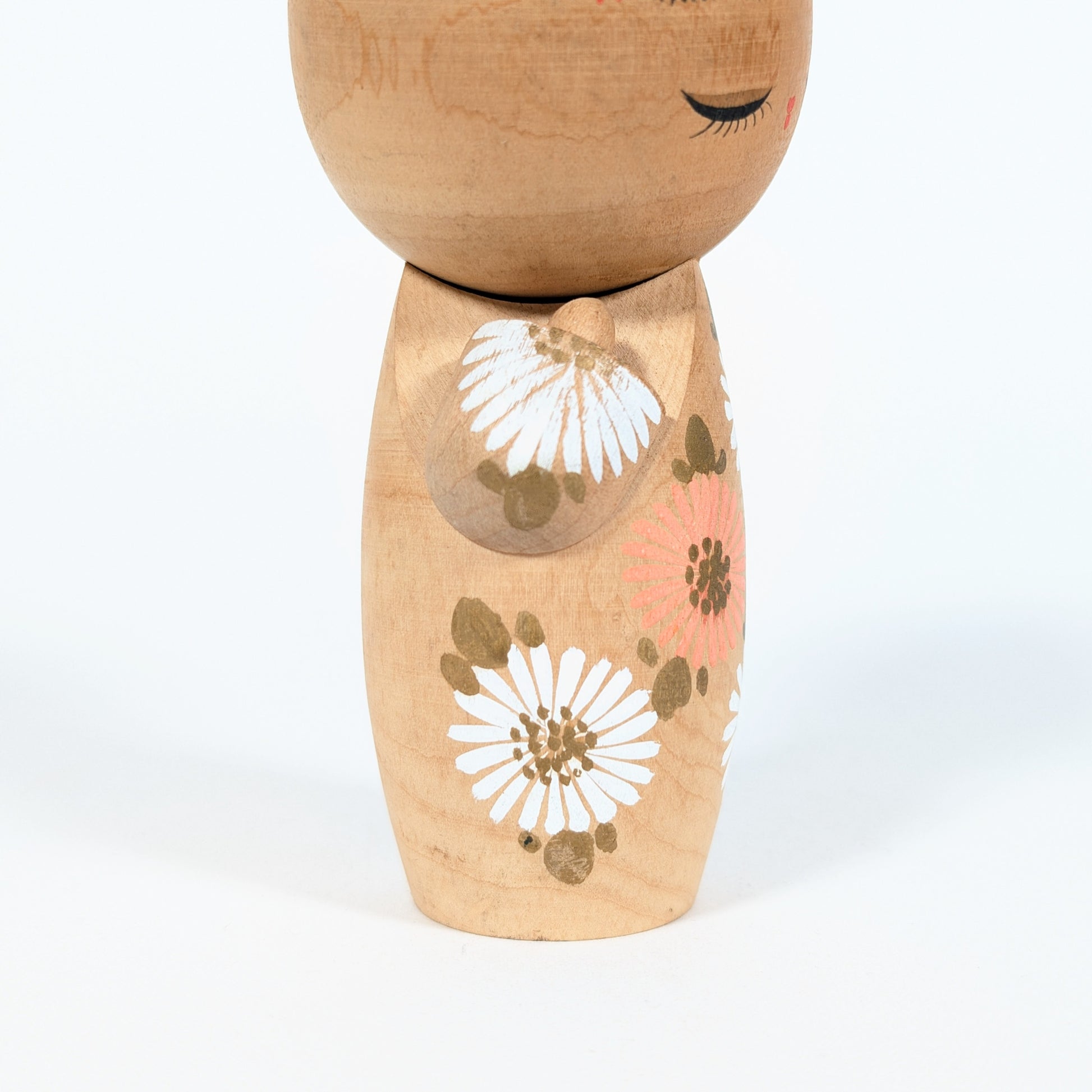 kokeshi japonaise visage yeux fermes fleurs blanches style sosaku artisanat japonais