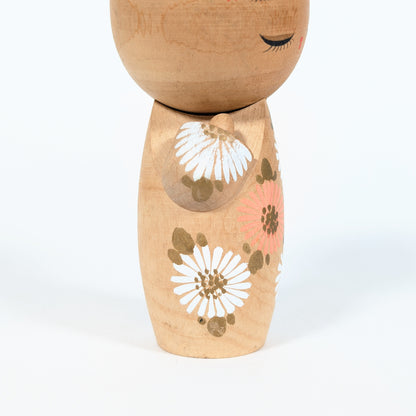 kokeshi japonaise visage yeux fermes fleurs blanches style sosaku artisanat japonais