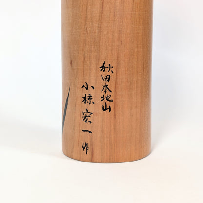 Dos d’une kokeshi japonaise traditionnelle en bois de yamazakura, finition naturelle artisanale