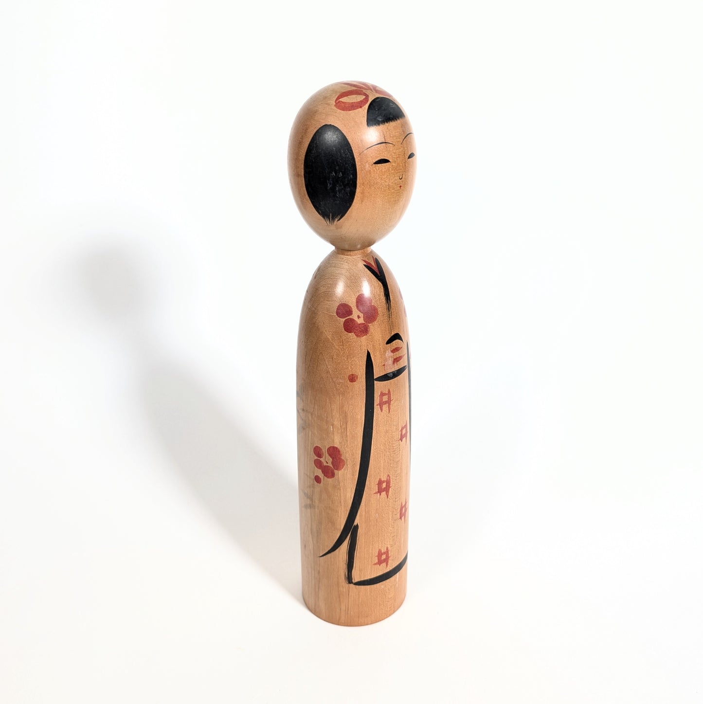 Profil d’une kokeshi Kijiyama poupée japonaise artisanale en bois style traditionnel