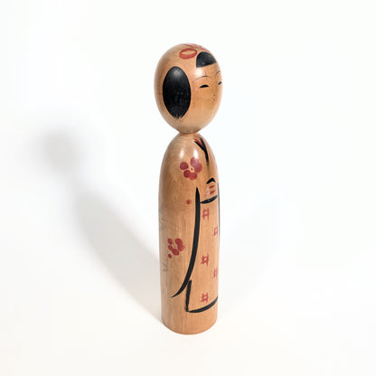 Profil d’une kokeshi Kijiyama poupée japonaise artisanale en bois style traditionnel
