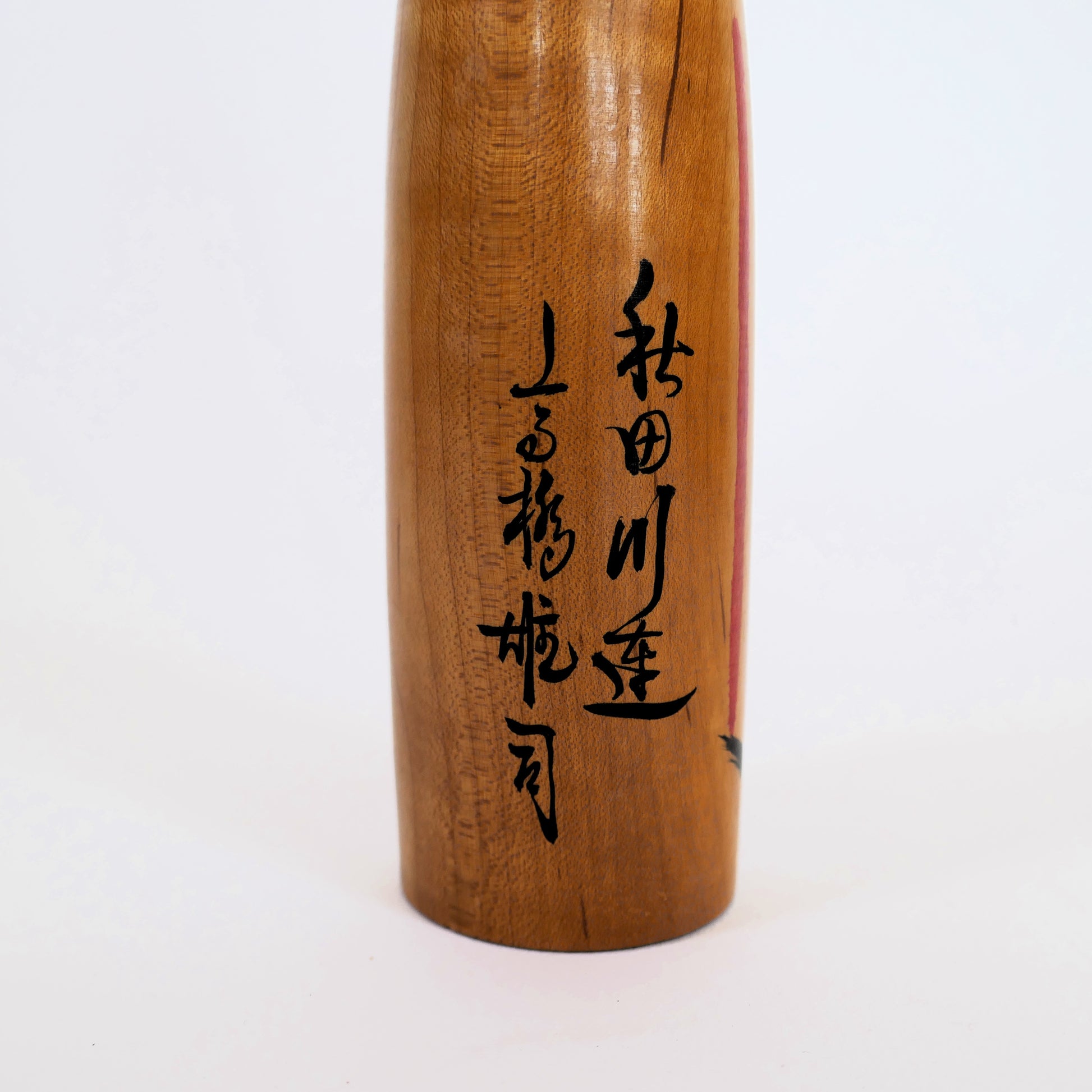 Signature de l’artisan Takahashi Yuji sur une kokeshi Kijiyama – calligraphie au dos de la poupée