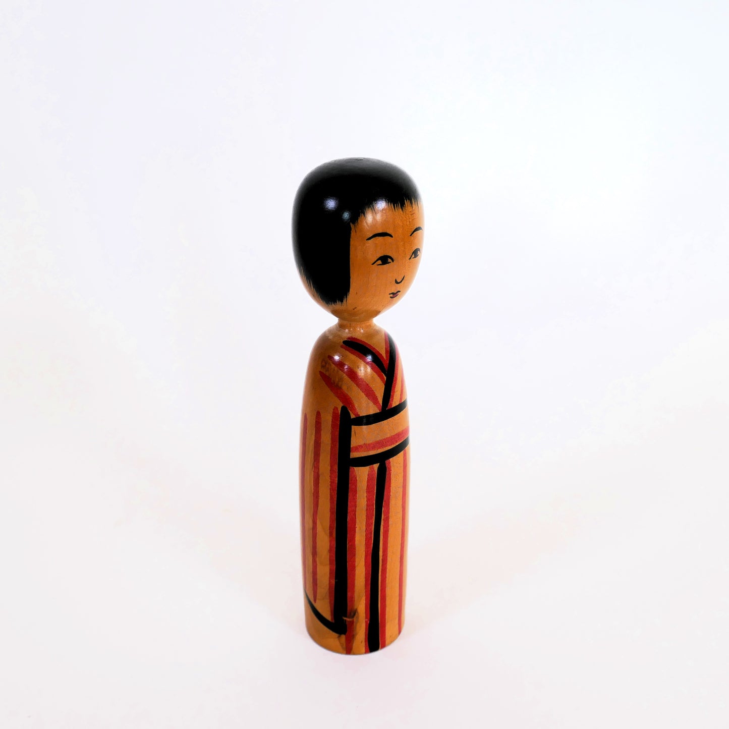 Kokeshi japonaise Kijiyama vue de profil, kimono rayé rouge et noir – artisanat d’Akita par Takahashi Yuji