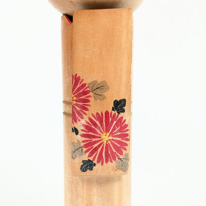 Détail du kimono en bois peint d'une kokeshi, décor de chrysanthèmes japonais kiku rouges, gris et noirs