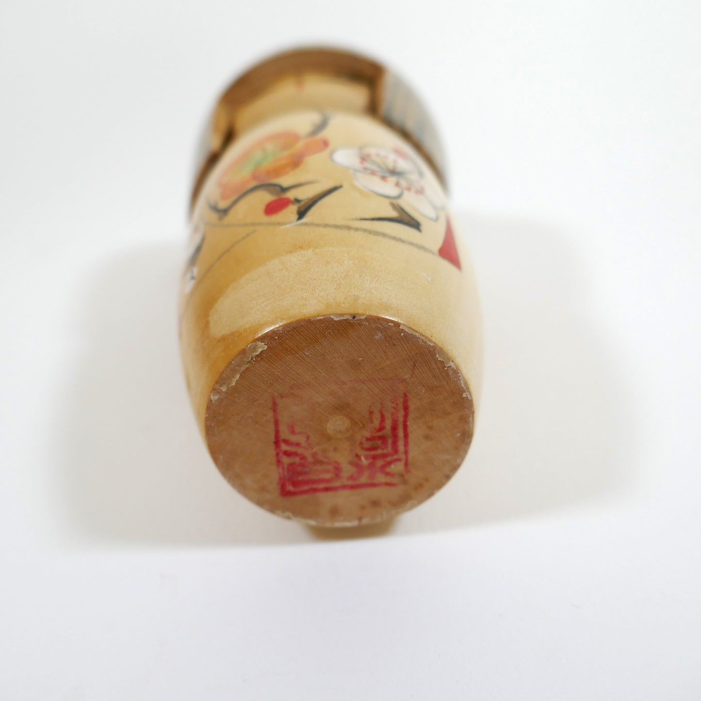 Base signée au tampon rouge (hanko) de la kokeshi Shigemi Tanaka, poupée en bois japonaise de 15 cm — signature d’atelier.