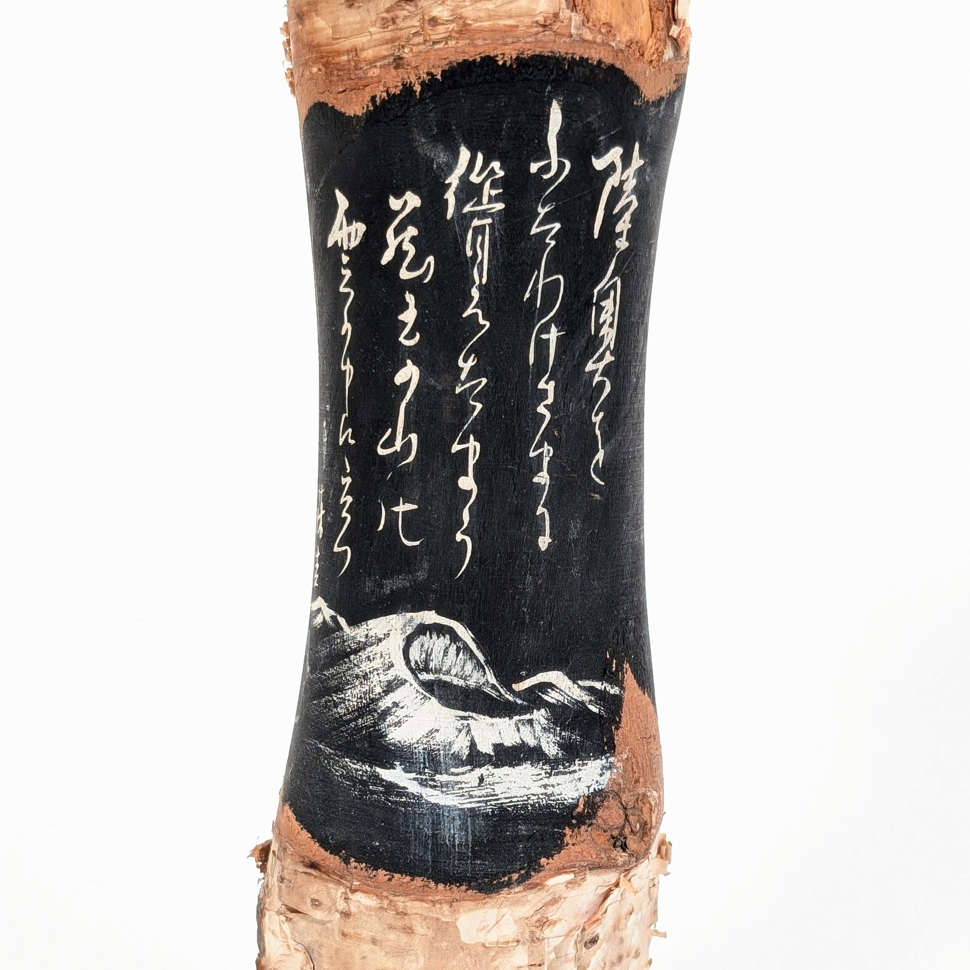 Détail du décor noir d’une kokeshi Zao Onsen avec calligraphie japonaise blanche, poème et mont Zao peint