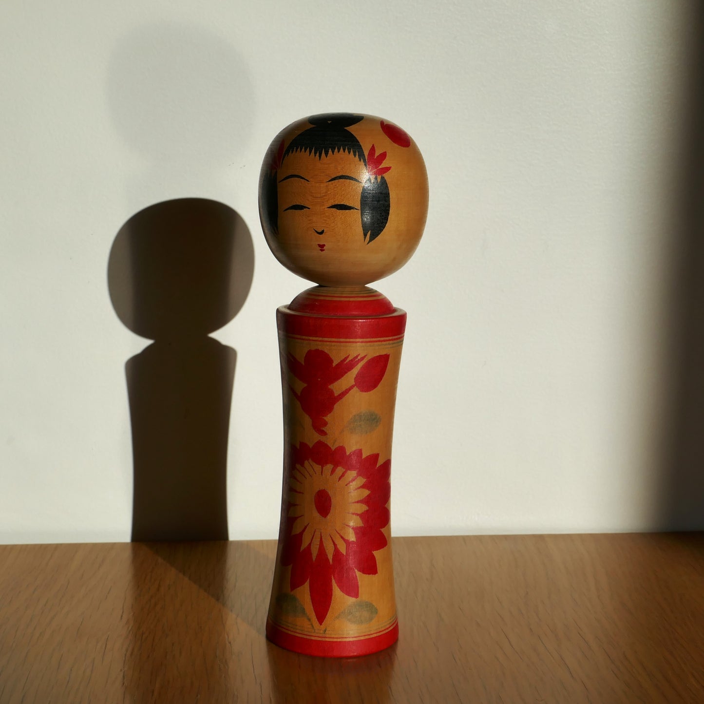 Une kokeshi Naruko peinte à la main, artisanat japonais traditionnel sous lumière naturelle