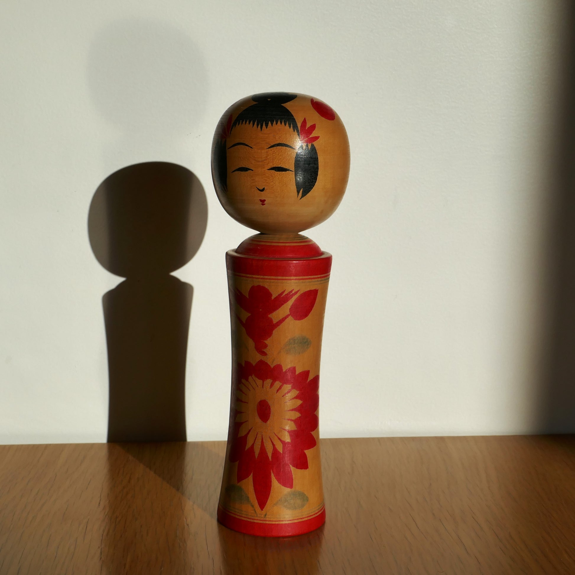Une kokeshi Naruko peinte à la main, artisanat japonais traditionnel sous lumière naturelle