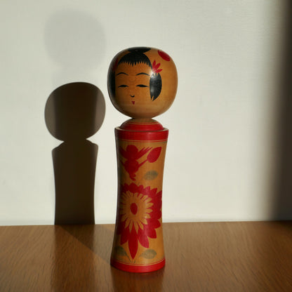 Une kokeshi Naruko peinte à la main, artisanat japonais traditionnel sous lumière naturelle