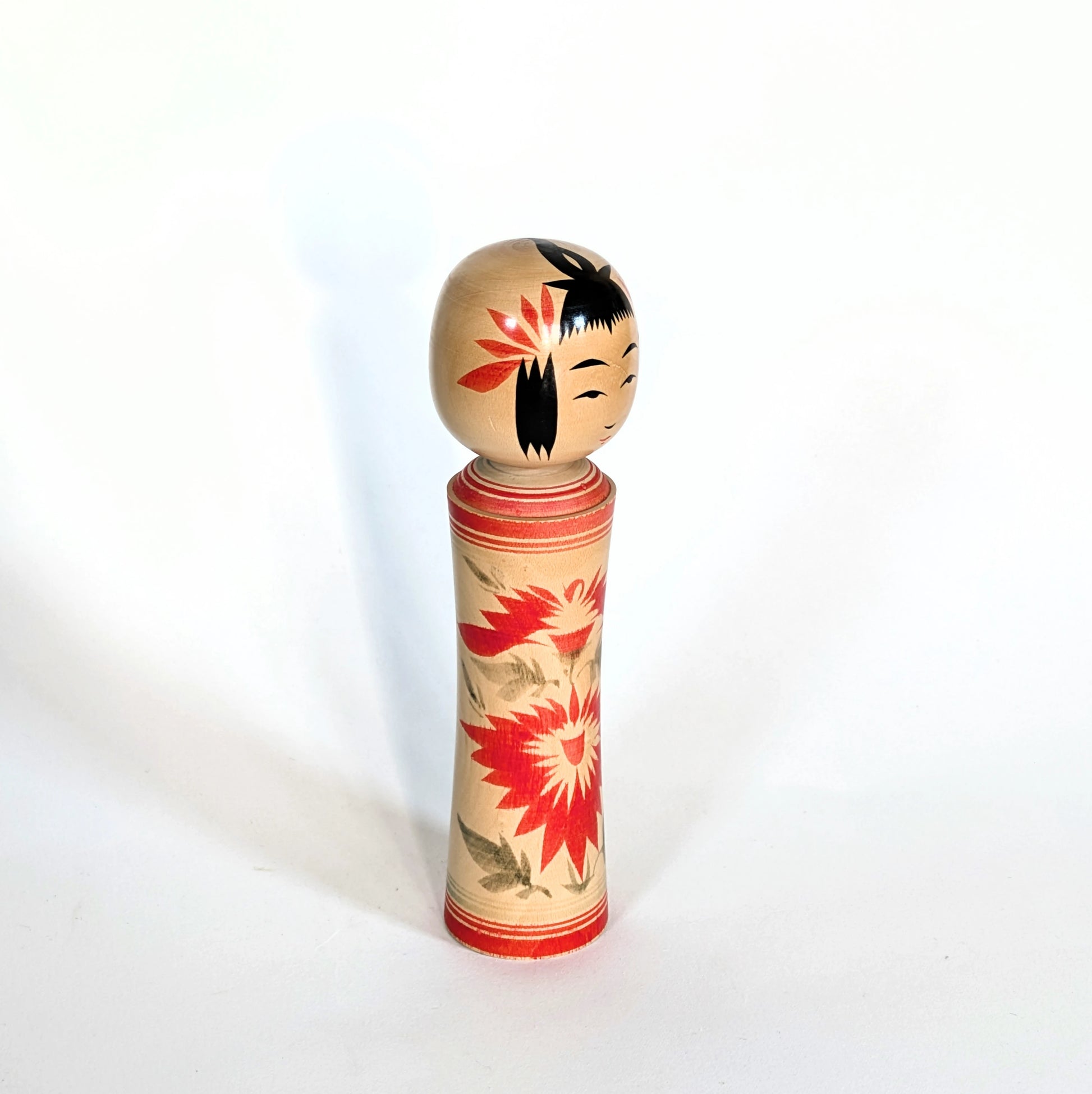 Poupée japonaise kokeshi de style Naruko traditionnel, vue en trois-quarts droit.