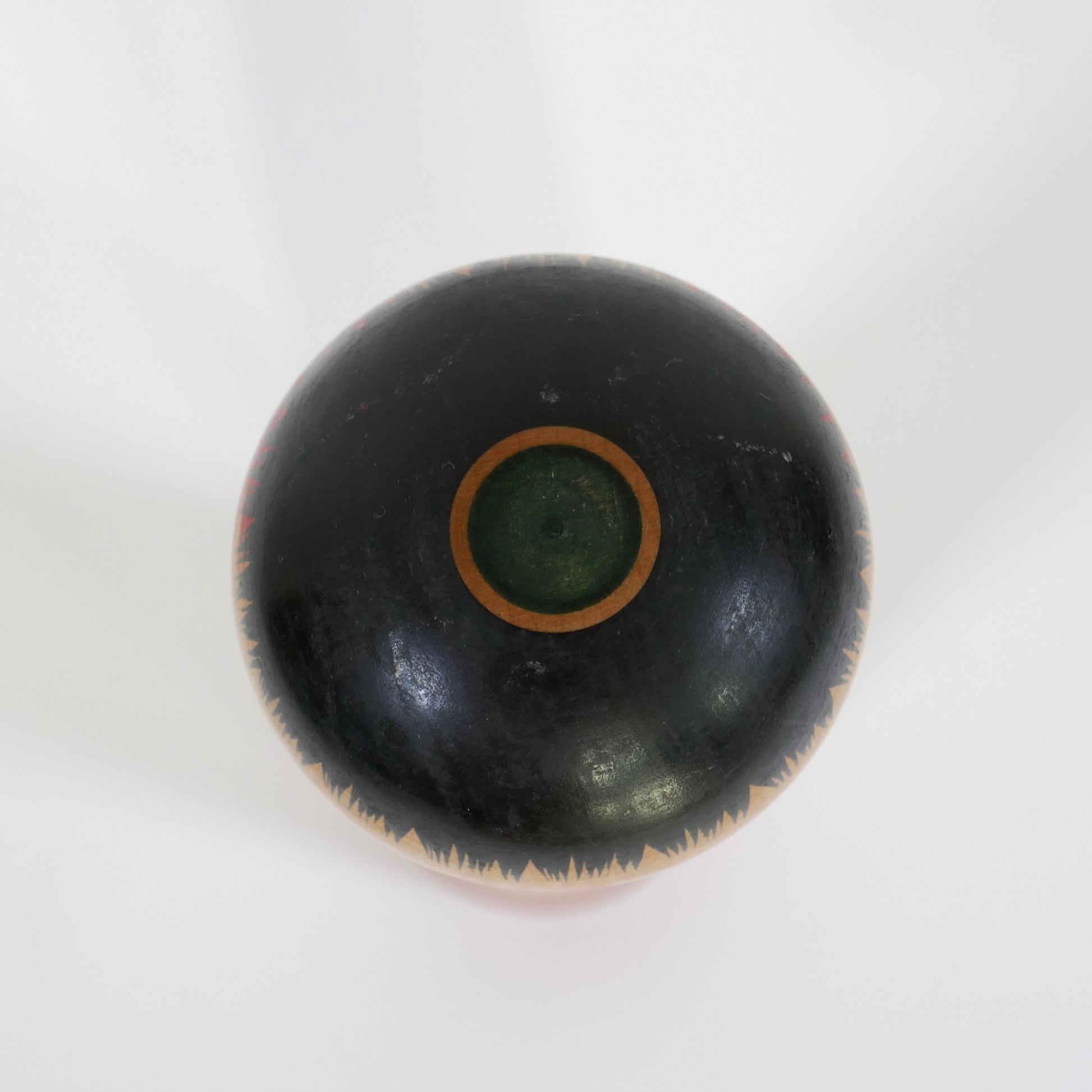 Détail du sommet de la tête d'une kokeshi traditionnelle japonaise – cercle vert typique du style Ginzan Oshin
