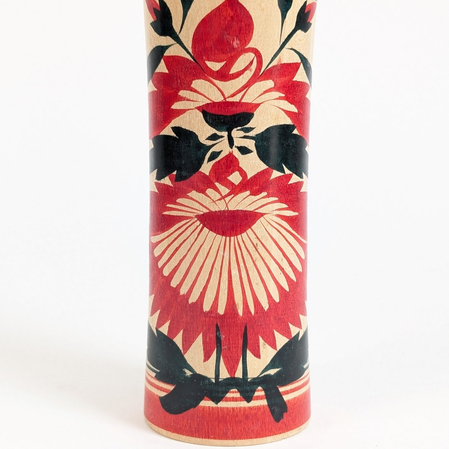 Décor hishigiku 菱菊 sur une kokeshi Naruko traditionnelle, grand chrysanthème stylisé rouge et noir peint sur bois naturel.